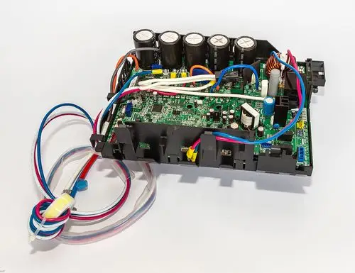 Daikin Platine mit elektronischen Komponenten, mehreren Kondensatoren und Kabelanschlüssen, auf hellem Hintergrund, zur Nutzung in Klimaanlagen oder Heizsystemen.